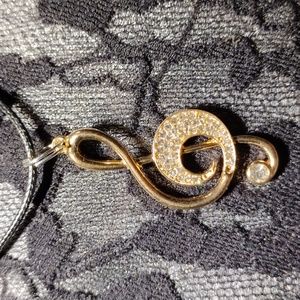 18-22",black cotton necklace w/a gold plated w/rhinestones treble- clef pendant.